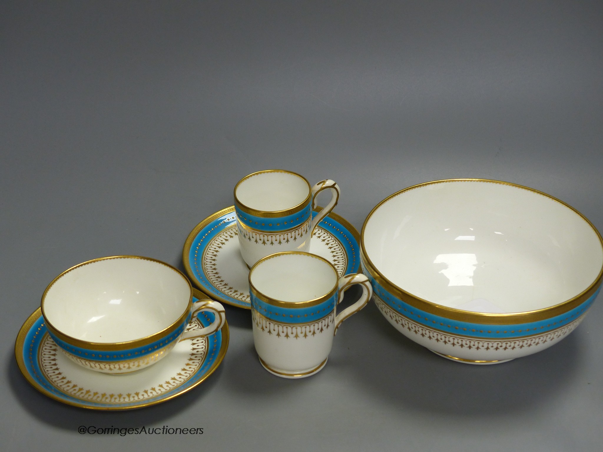 A Minton coffee cup, teacup and saucer with turquoise and gold jewelled band under a gold acid etched border, a matching coffee cup and saucer and a bowl